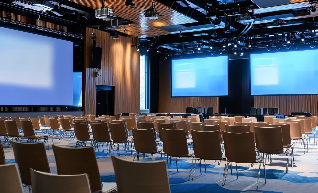 会場スクリーン前に整列した客席。決算発表会での同時通訳の様子